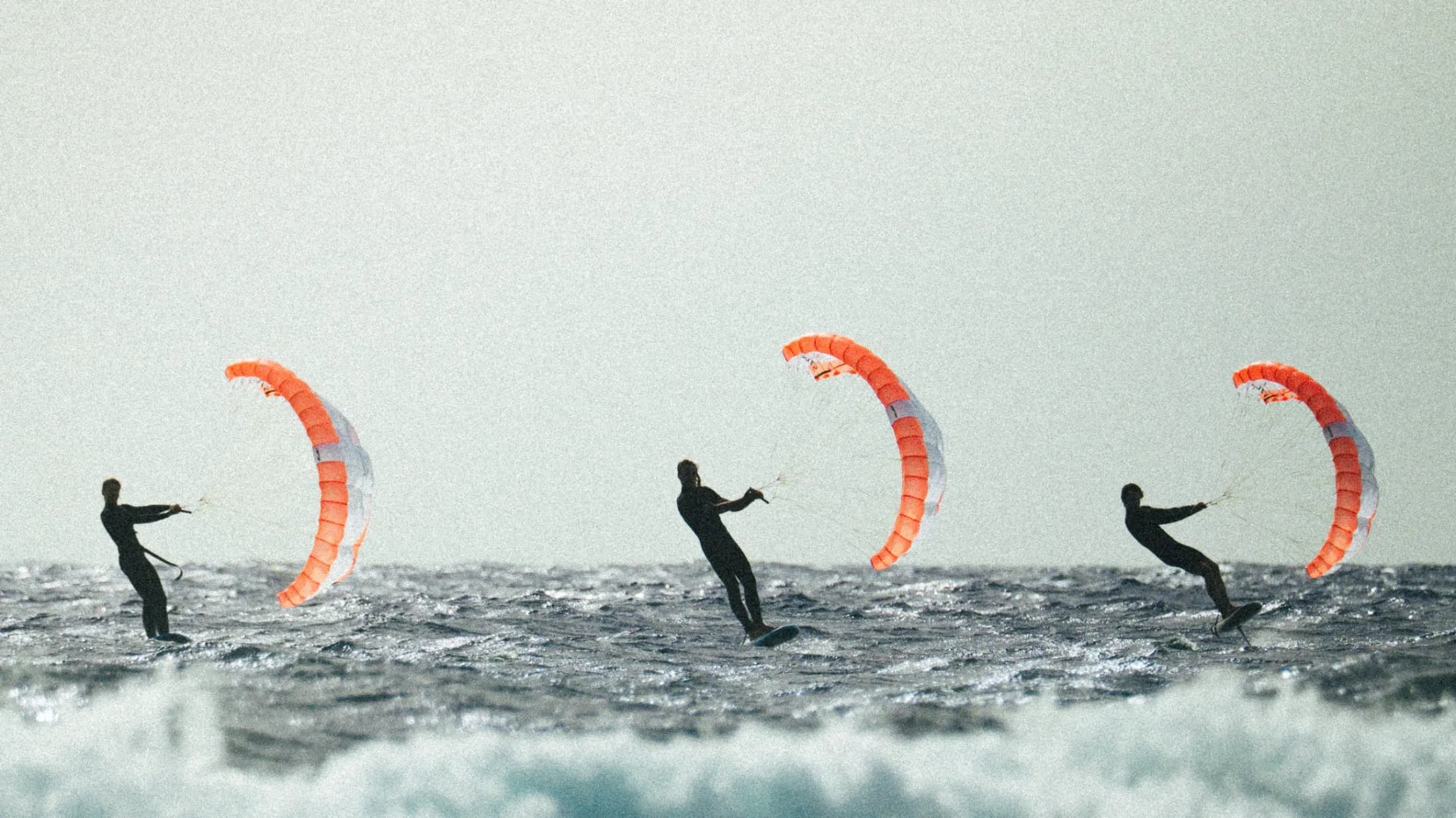 Three riders parawing foiling offshore